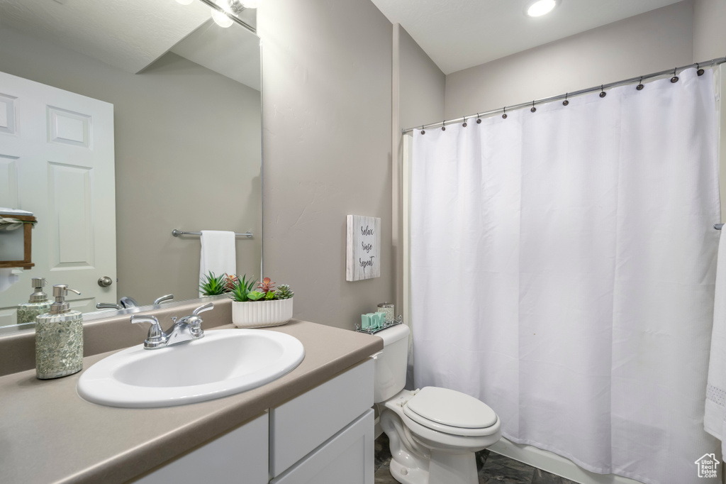 Bathroom with vanity, toilet, and a shower with curtain