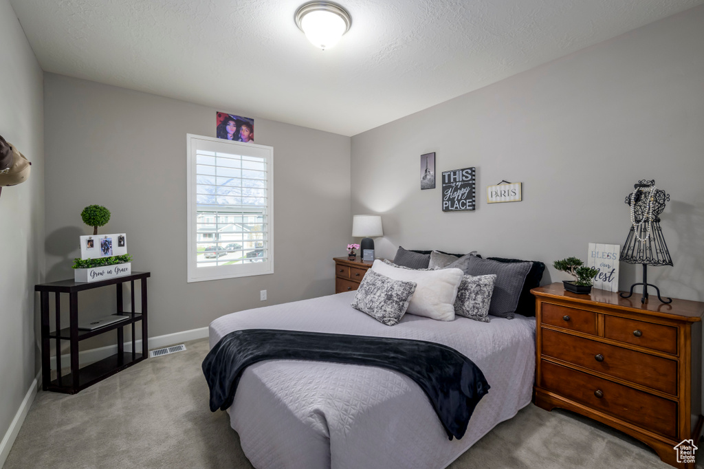 Bedroom featuring light carpet and baseboards
