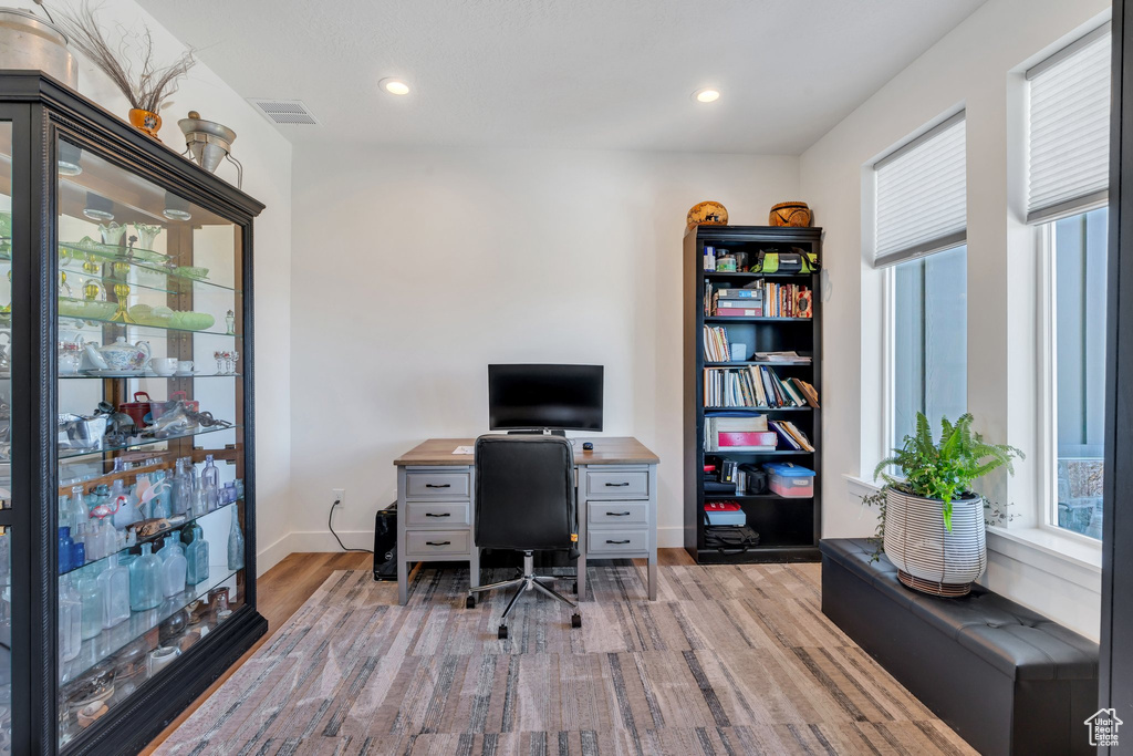 Office space with light wood finished floors and recessed lighting