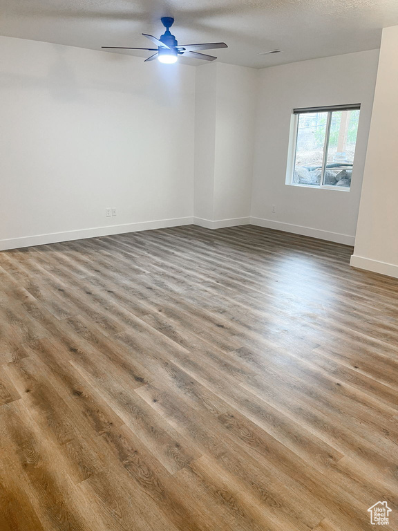 Spare room featuring wood finished floors and a ceiling fan