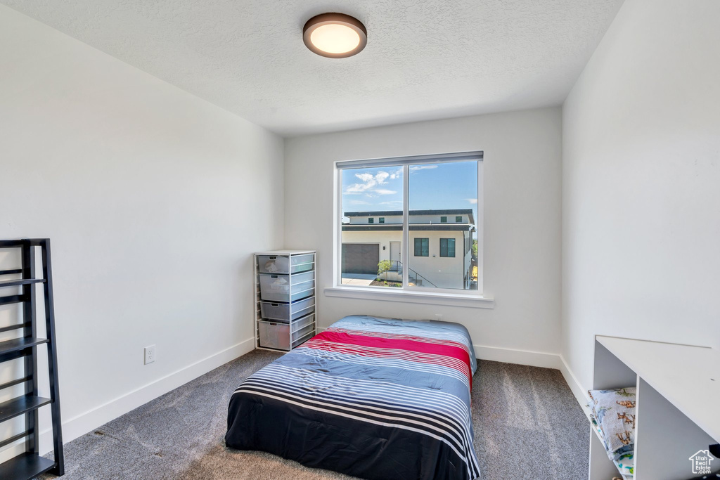 Bedroom featuring carpet floors and a textured ceiling