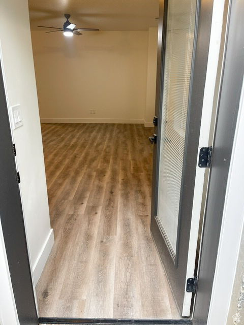 Hallway featuring wood finished floors and baseboards