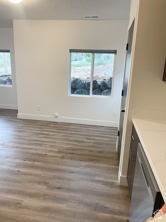 Unfurnished dining area featuring dark wood-type flooring and healthy amount of natural light