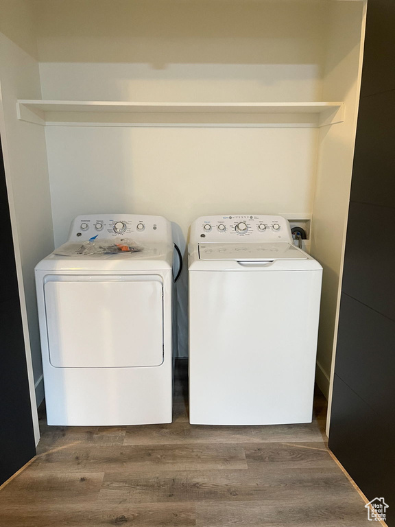 Laundry room with washer and clothes dryer and wood finished floors