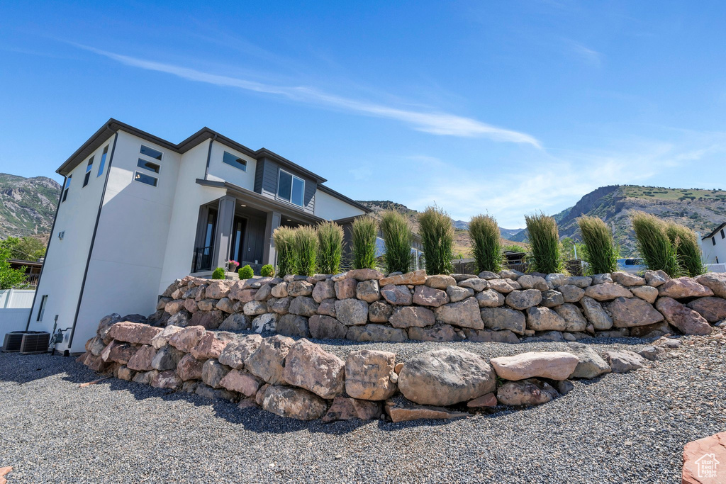 View of side of home with a mountain view and stucco siding