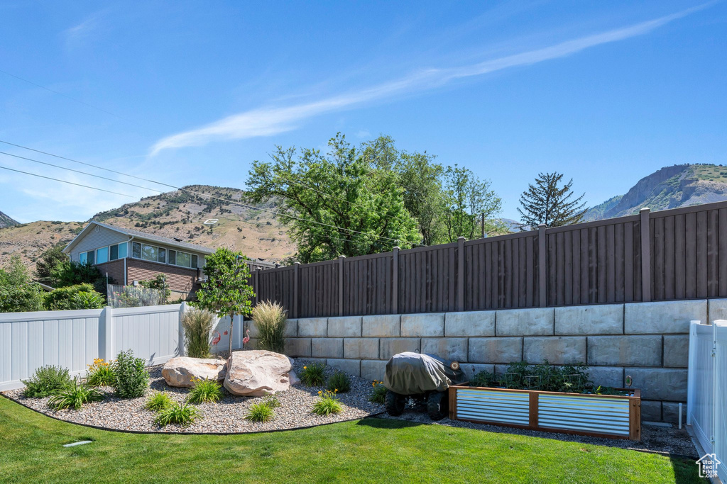 Fenced backyard featuring a mountain view