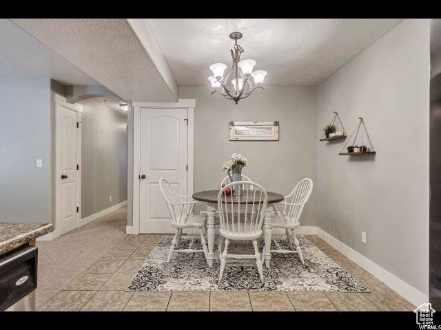 Dining room featuring a chandelier, baseboards, and light tile patterned floors