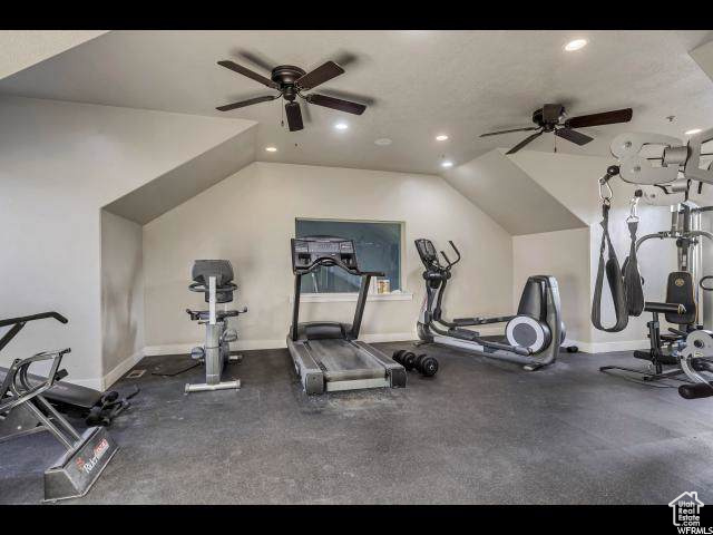 Workout area with a ceiling fan, recessed lighting, baseboards, and lofted ceiling