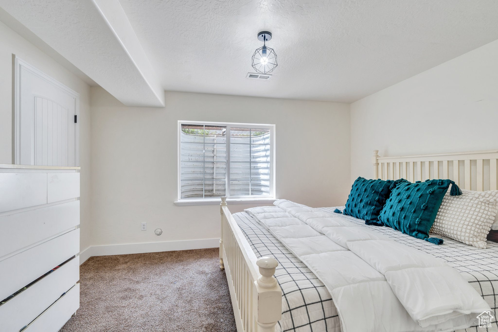 Carpeted bedroom with baseboards and a textured ceiling