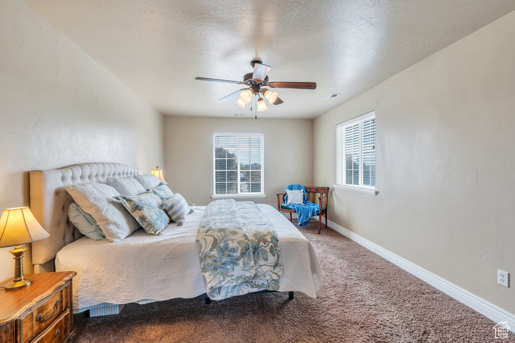 Carpeted bedroom with baseboards and a ceiling fan