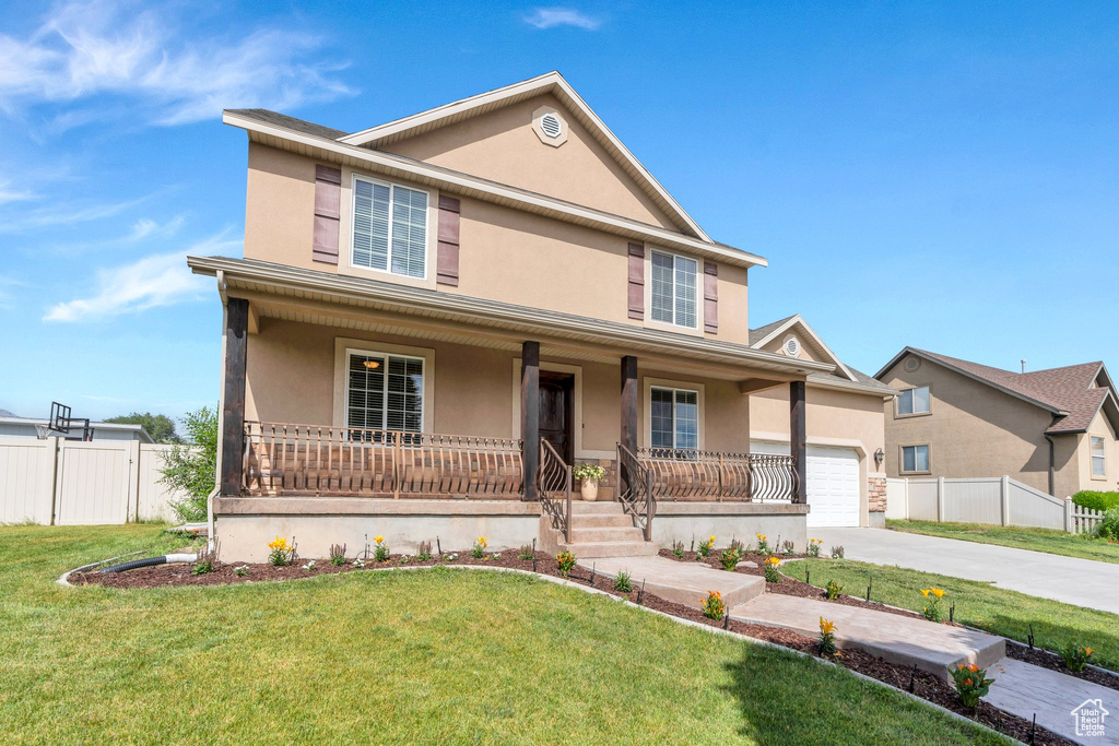 View of front of house featuring a porch, stucco siding, driveway, and a garage
