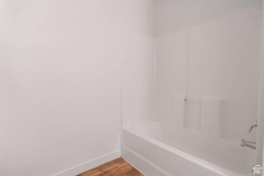 Bathroom featuring wood finished floors and bathtub / shower combination