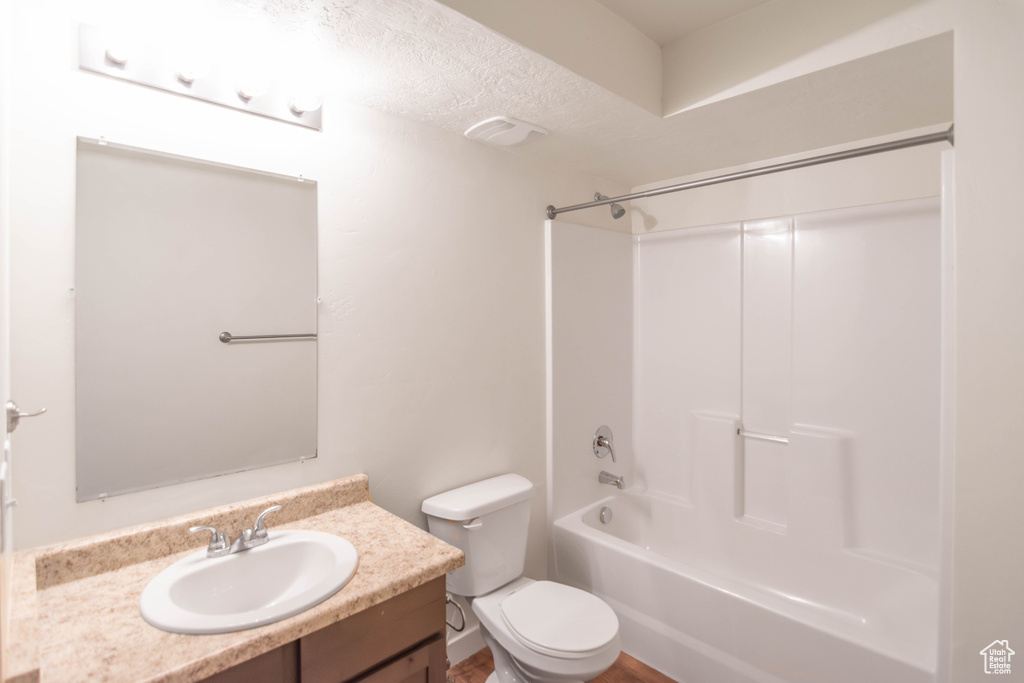Bathroom featuring vanity,  shower combination, and a textured ceiling