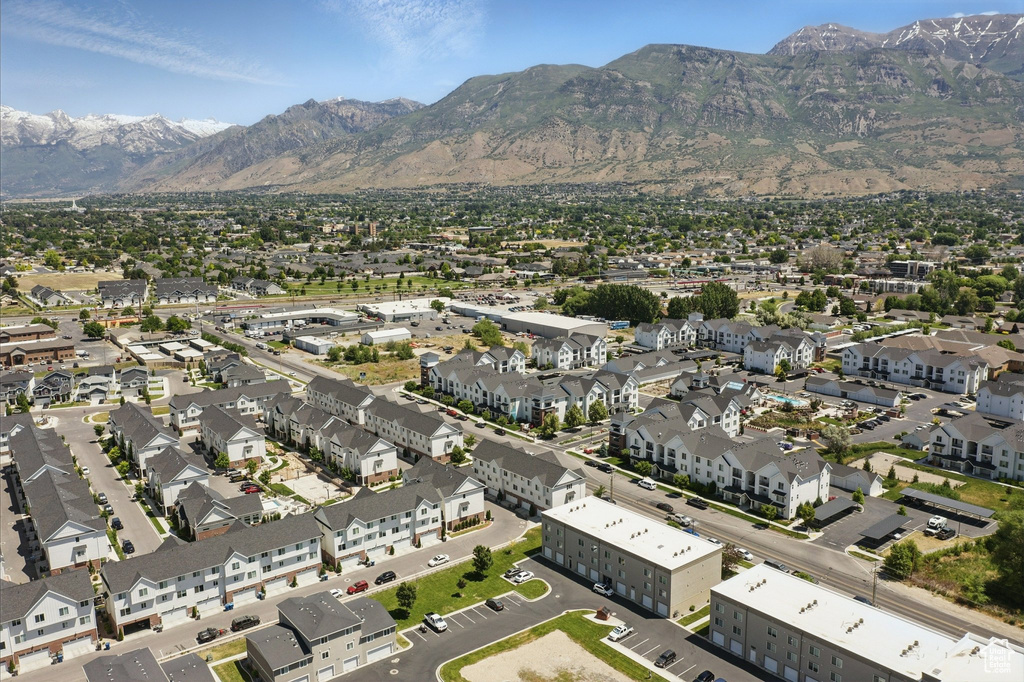 Aerial view of property and surrounding area with mountains and nearby suburban area