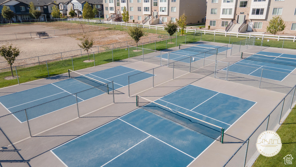 View of tennis court with a residential view