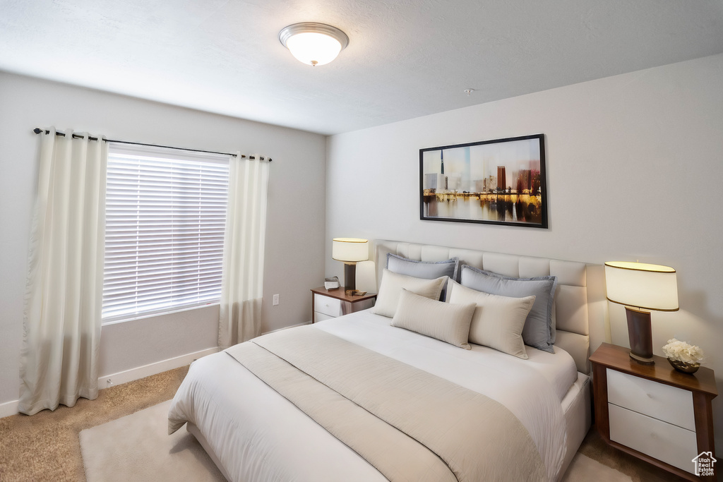 Bedroom featuring light colored carpet and baseboards
