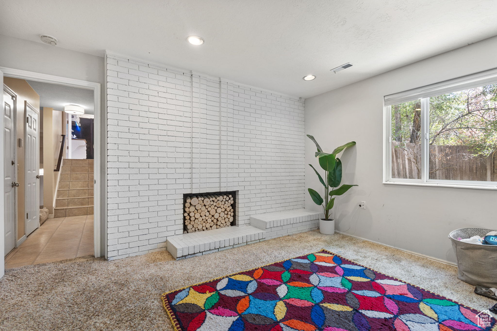 Sitting room with carpet floors, a brick fireplace, recessed lighting, and stairway