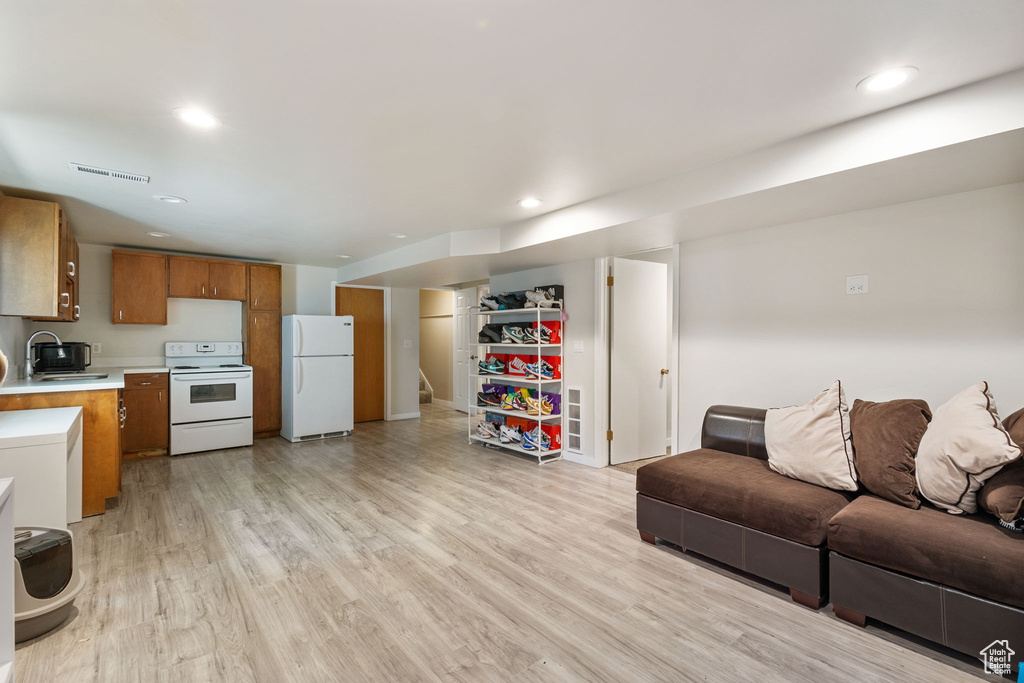 Living room with light wood-style flooring and recessed lighting