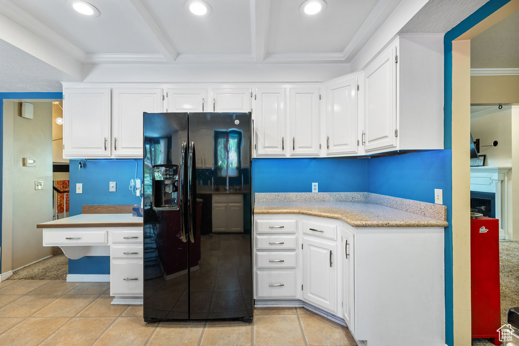 Kitchen featuring black fridge with ice dispenser, ornamental molding, white cabinetry, recessed lighting, and beamed ceiling