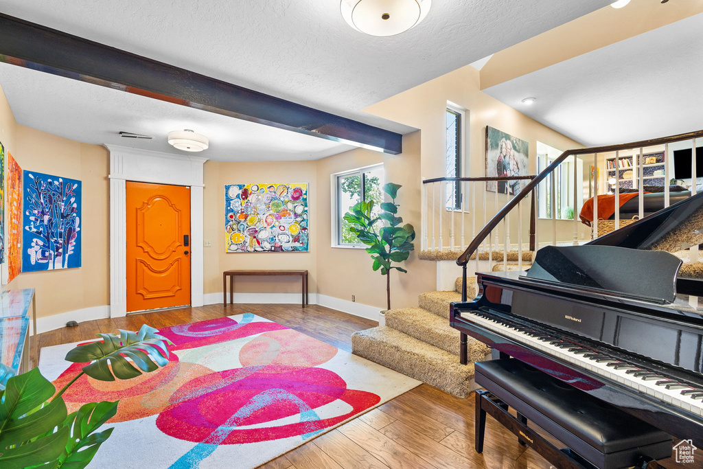 Entryway featuring hardwood / wood-style flooring, stairway, and a textured ceiling