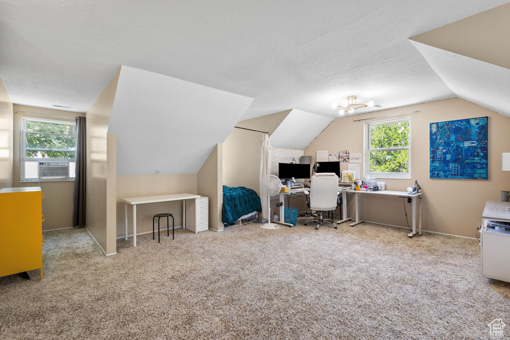 Office featuring vaulted ceiling, plenty of natural light, carpet, a textured ceiling, and cooling unit
