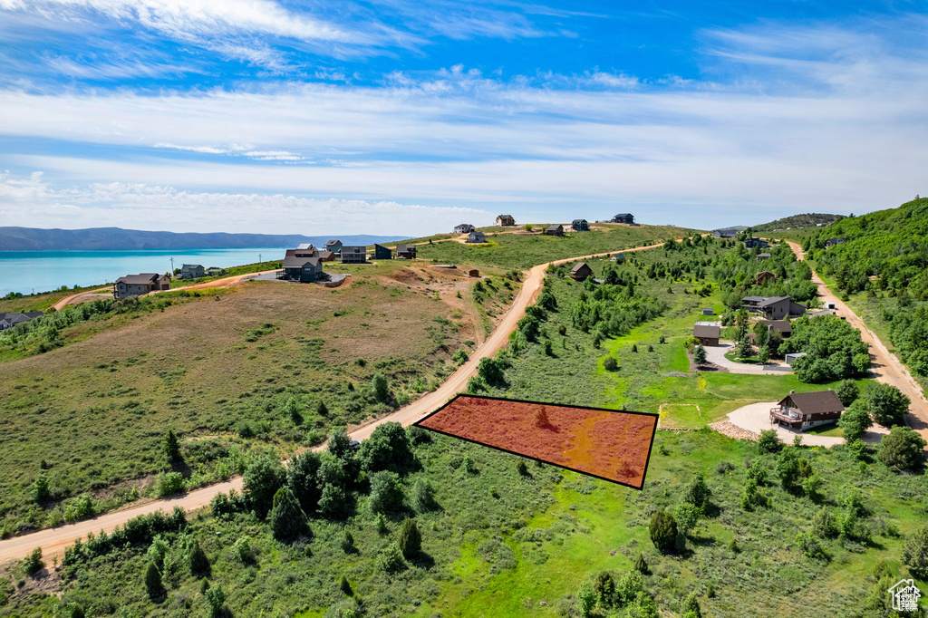 Aerial view of property and surrounding area featuring a nearby body of water and property boundaries highlighted