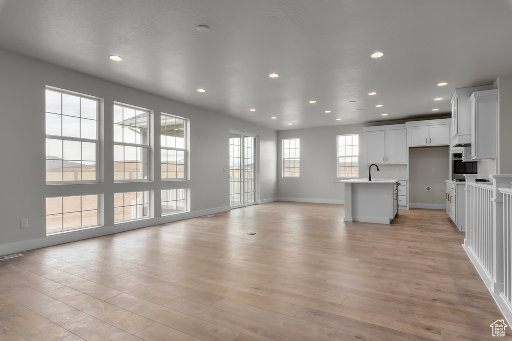 Unfurnished living room featuring recessed lighting and light wood-style flooring