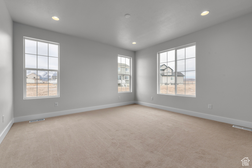 Unfurnished room with recessed lighting and light carpet
