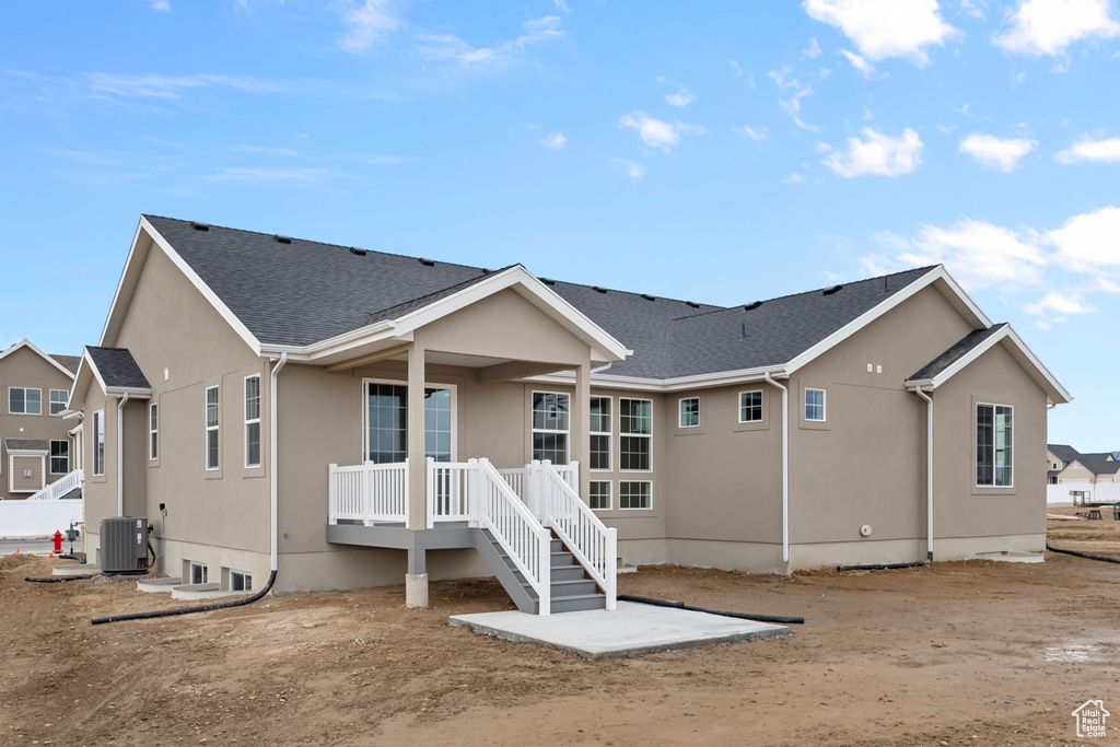 Rear view of house with stucco siding and a shingled roof