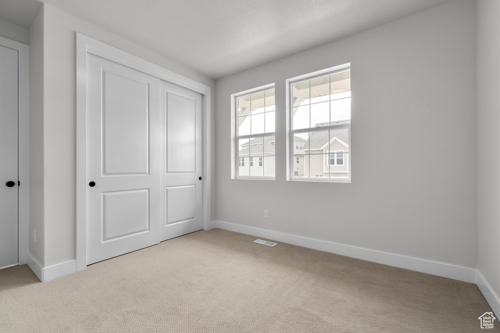 Unfurnished bedroom featuring carpet flooring and a closet