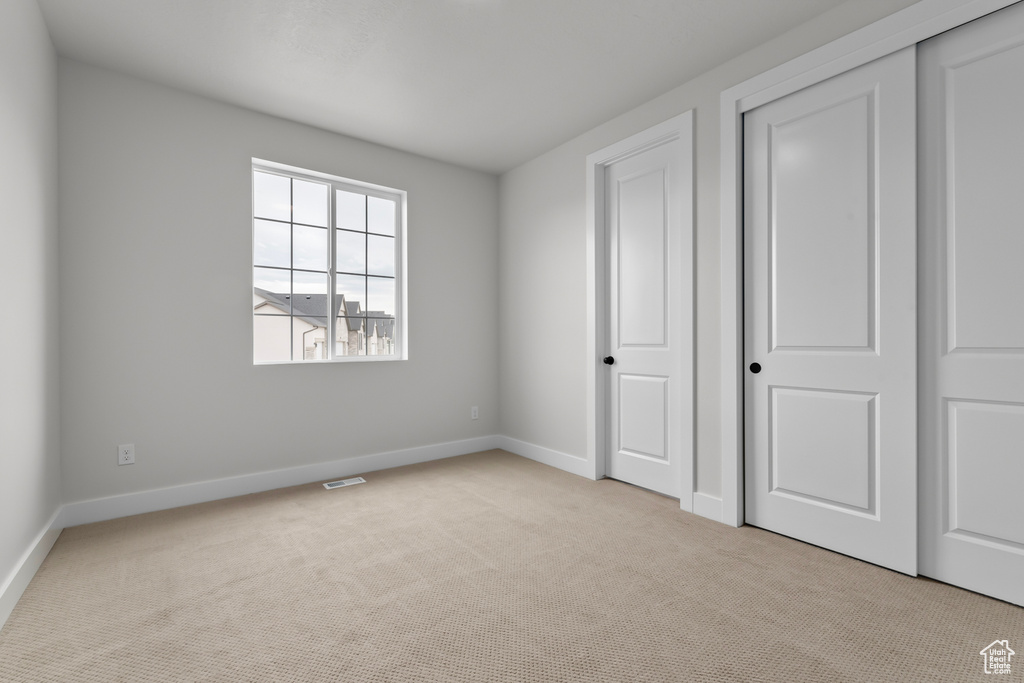 Unfurnished bedroom featuring carpet floors and a closet