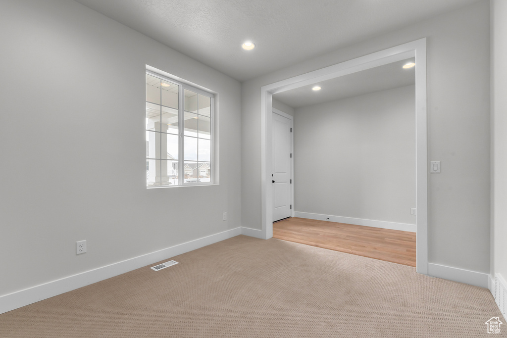 Spare room with light colored carpet and recessed lighting
