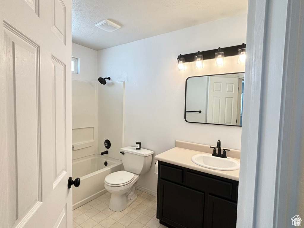 Full bathroom with vanity, tile patterned floors, toilet, a textured ceiling, and shower / bath combination