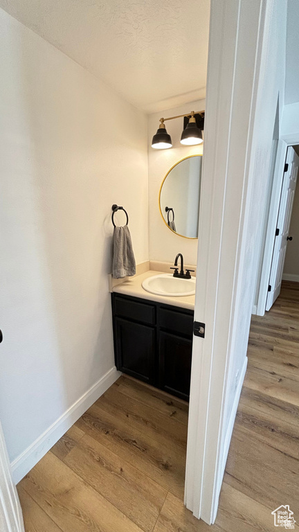 Bathroom featuring vanity, wood-type flooring, and a textured ceiling