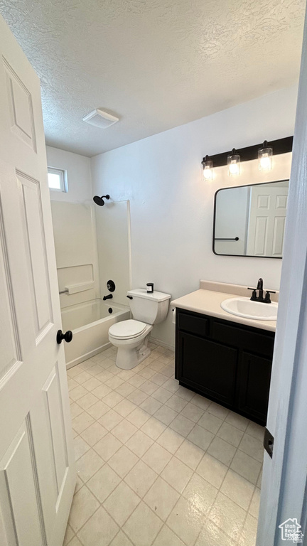 Full bathroom featuring tile patterned flooring, a textured ceiling, toilet, vanity, and bathtub / shower combination