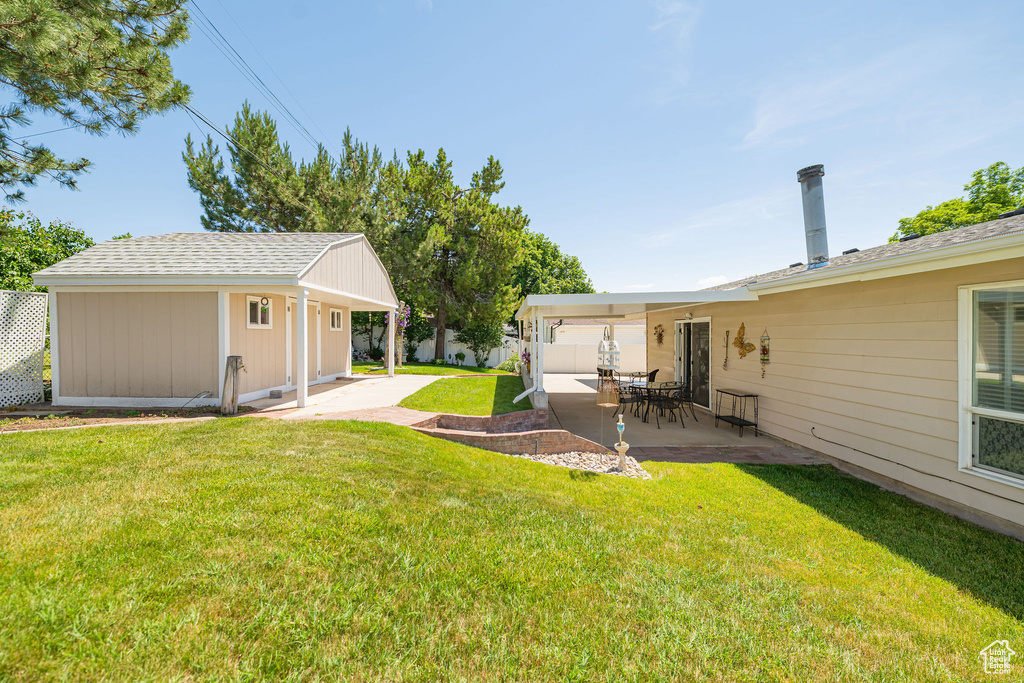 View of yard featuring a patio area and an outbuilding