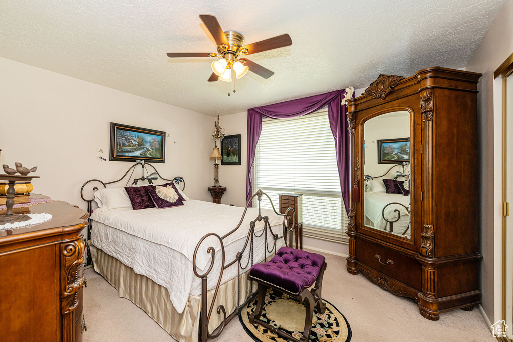Bedroom with light colored carpet and ceiling fan