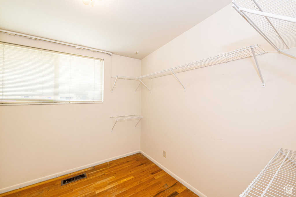Walk in closet with wood finished floors