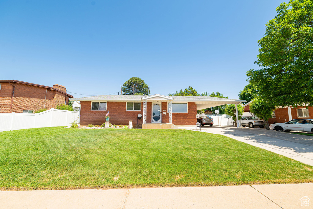 View of front of property with a carport, concrete driveway, and brick siding