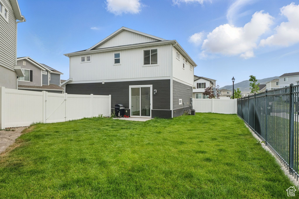 Rear view of house with a fenced backyard and a gate