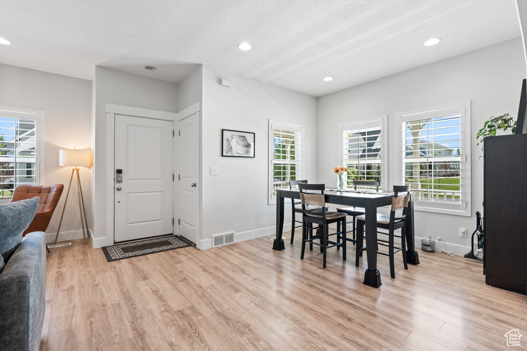 Dining space with light wood-style floors and recessed lighting