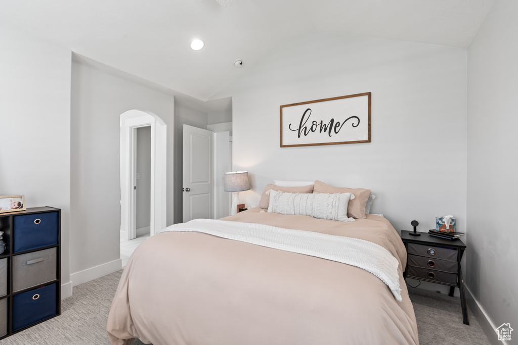 Bedroom featuring light carpet, arched walkways, vaulted ceiling, and recessed lighting