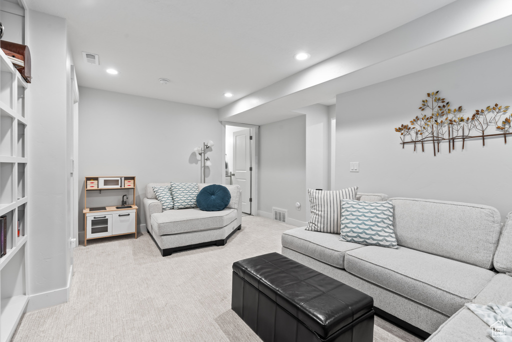 Living area featuring light colored carpet and recessed lighting