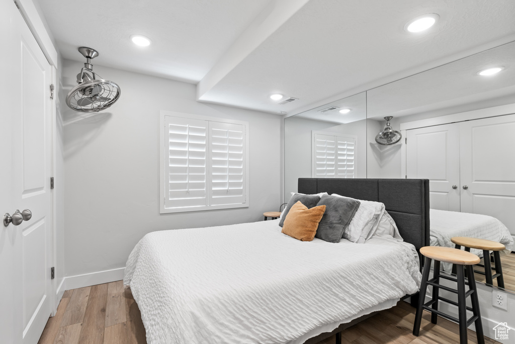 Bedroom featuring light wood-style floors, recessed lighting, and a closet