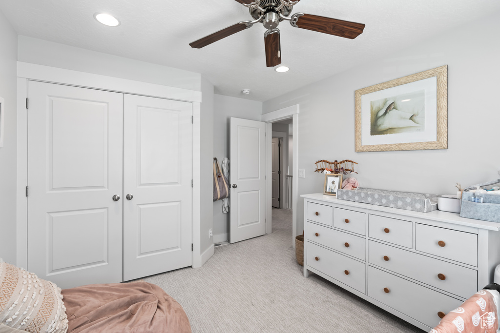 Bedroom with light carpet, a closet, recessed lighting, and ceiling fan