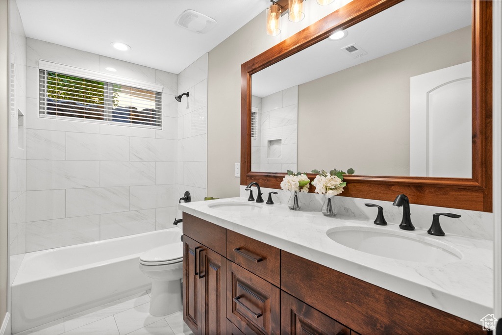 Full bath with  shower combination, double vanity, recessed lighting, and marble finish flooring
