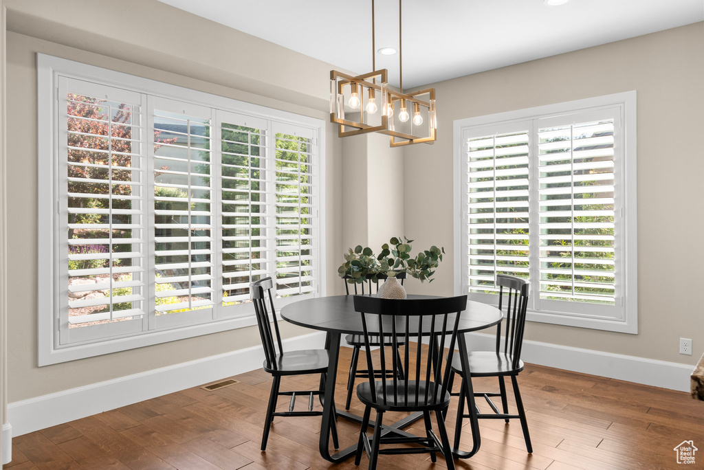 Dining room with a chandelier, plenty of natural light, recessed lighting, and wood finished floors