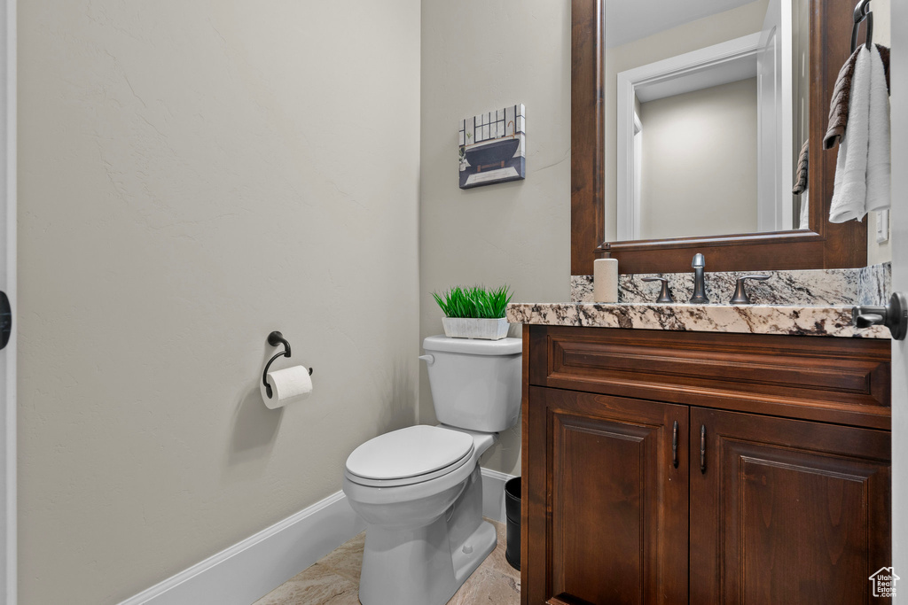 Half bath with baseboards and vanity