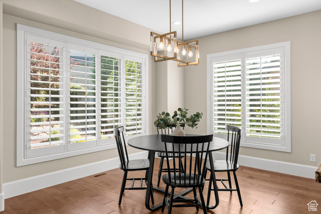 Dining area featuring a chandelier, healthy amount of natural light, recessed lighting, and wood finished floors