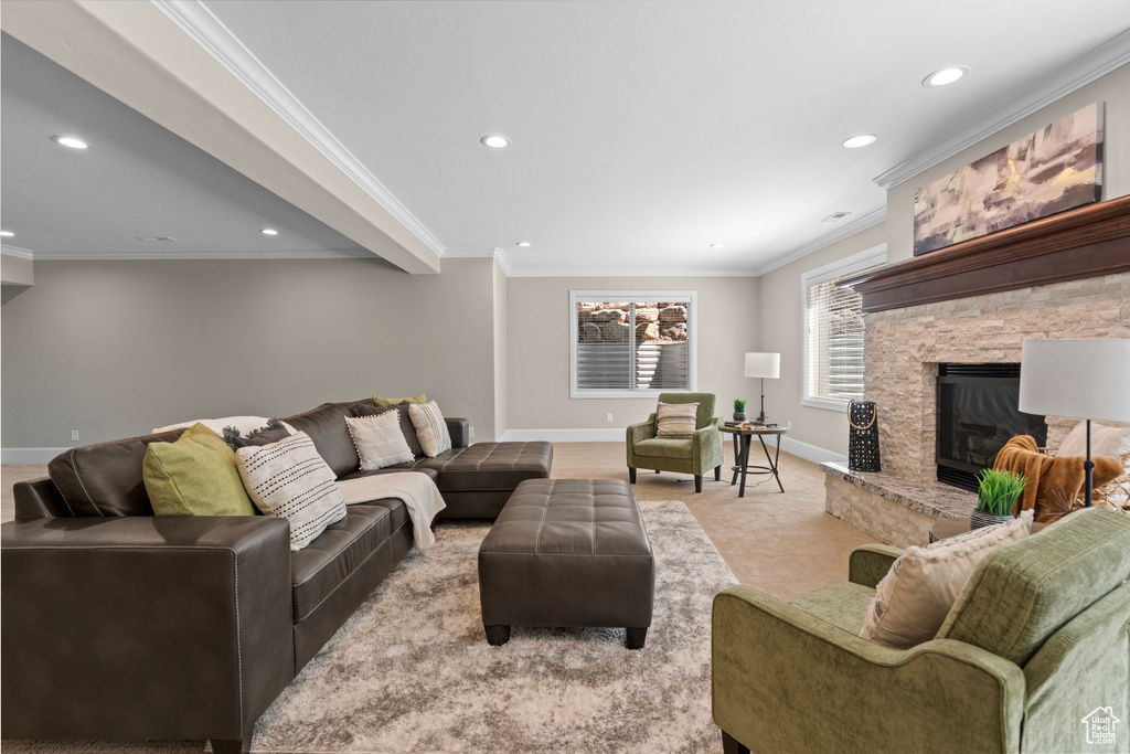 Living area with recessed lighting, a stone fireplace, ornamental molding, and carpet flooring